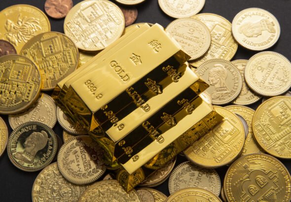Shiny gold bars stacked in a vault representing gold’s market value and safe-haven demand.