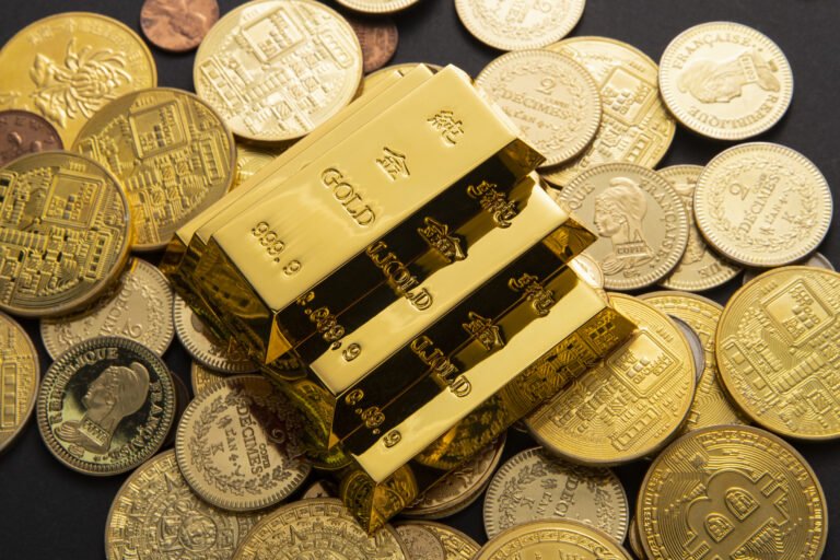 Shiny gold bars stacked in a vault representing gold’s market value and safe-haven demand.
